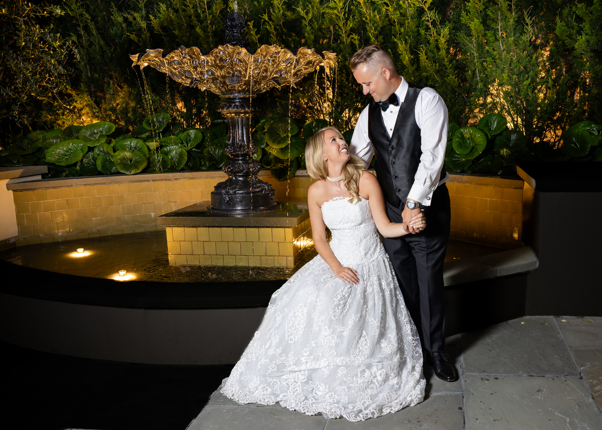 The bride and groom at the fountain at night at the New Orleans Board of Trade.
