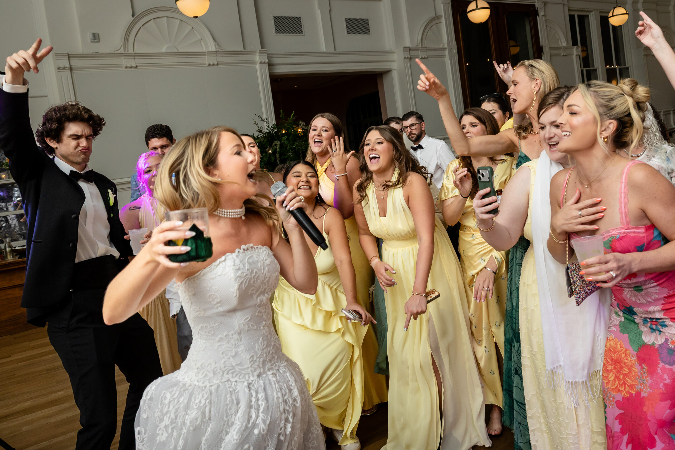 The bride sings to bridesmaids during the reception at the Board of Trade.