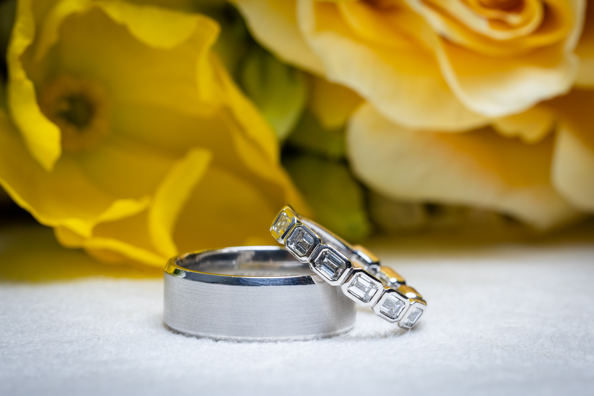 The wedding rings in front the the bridal bouquet.